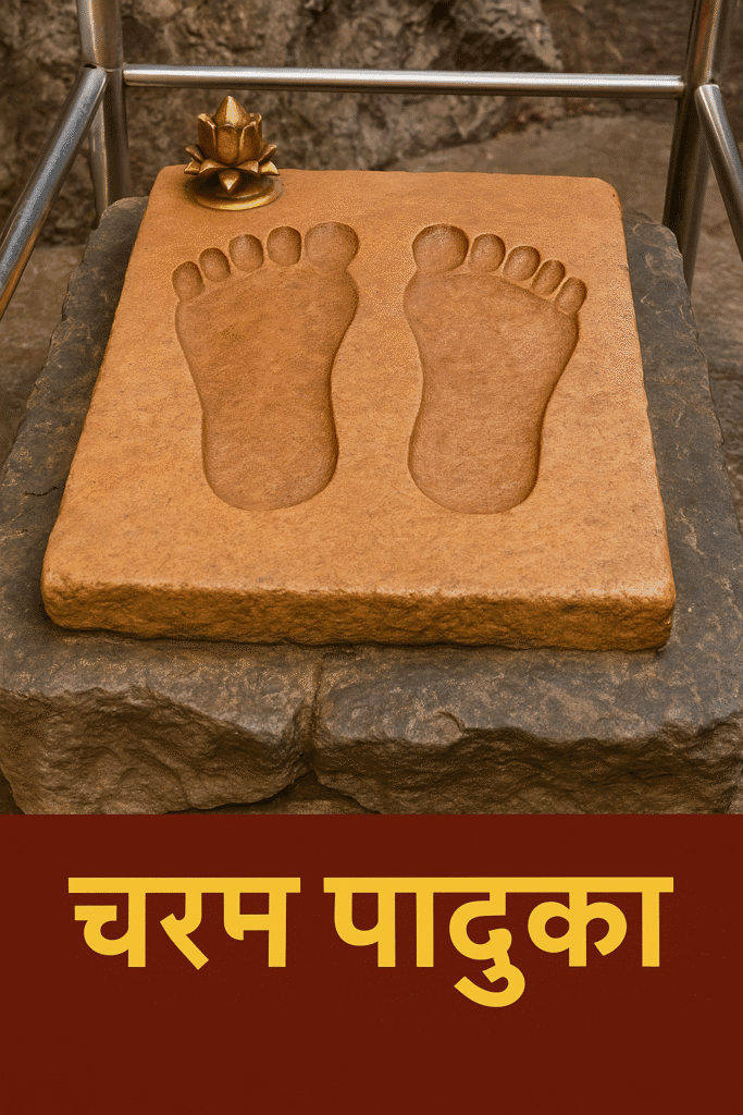 "Sacred Charan Paduka of Vaishno Devi Mata carved in stone, placed on a rocky pedestal with a brass lotus and surrounded by a railing, with 'चरन पादुका' written in Hindi below."
